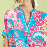 Blue and pink printed V-neck top with contrast trim, short sleeves (close-up)