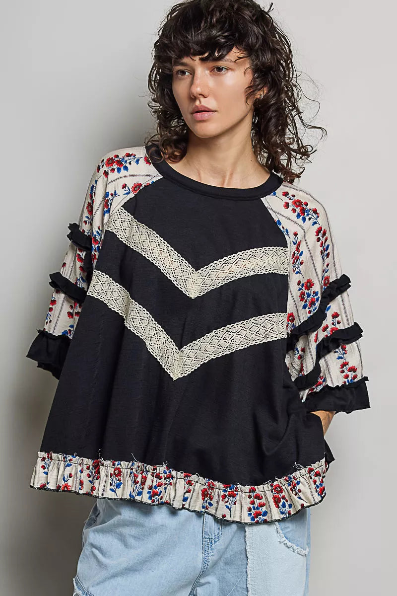 Black oversized knit top, round neck, contrast chevron lace, floral ruffle hem trim