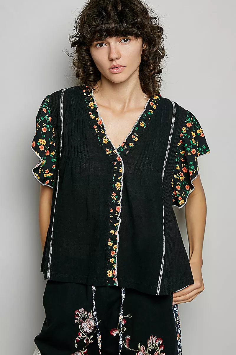 Black V-neck ruffle-sleeve blouse with floral border and pintuck front panels
