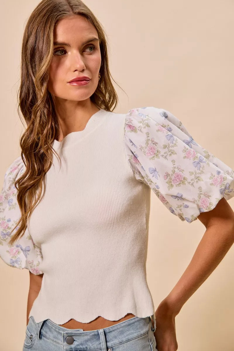 White ribbed sweater top with floral puff sleeves and scalloped hem detail