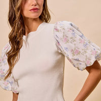 White ribbed sweater top with floral puff sleeves and scalloped hem detail