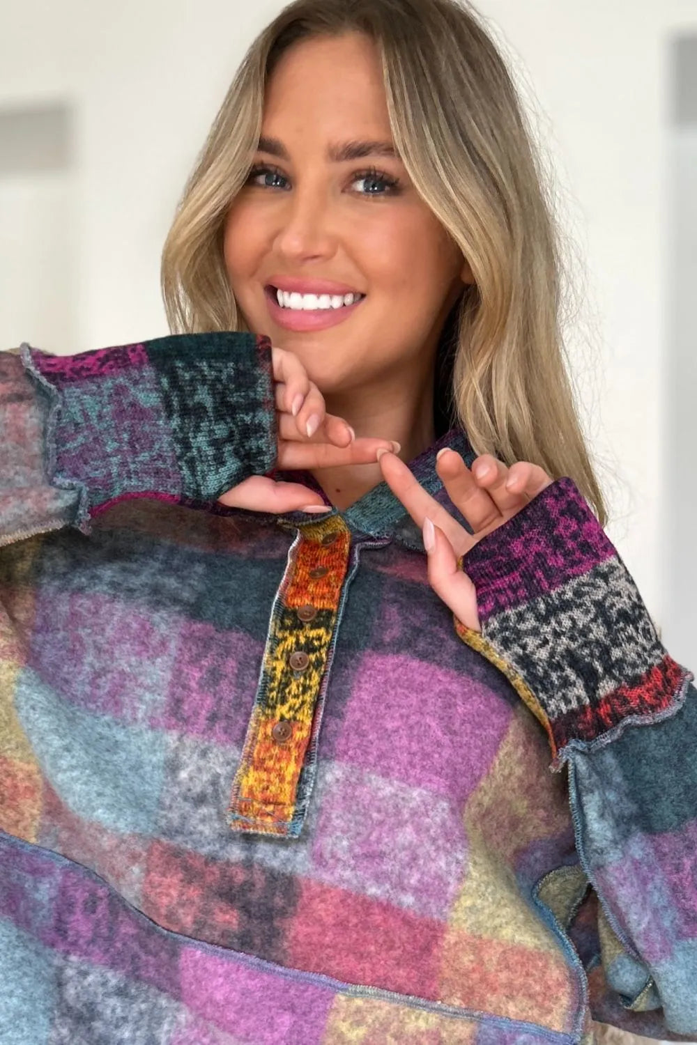Multicolor plaid fleece hoodie close-up with hood, quarter-zip placket, and patterned fabric