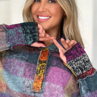 Multicolor plaid fleece hoodie close-up with hood, quarter-zip placket, and patterned fabric