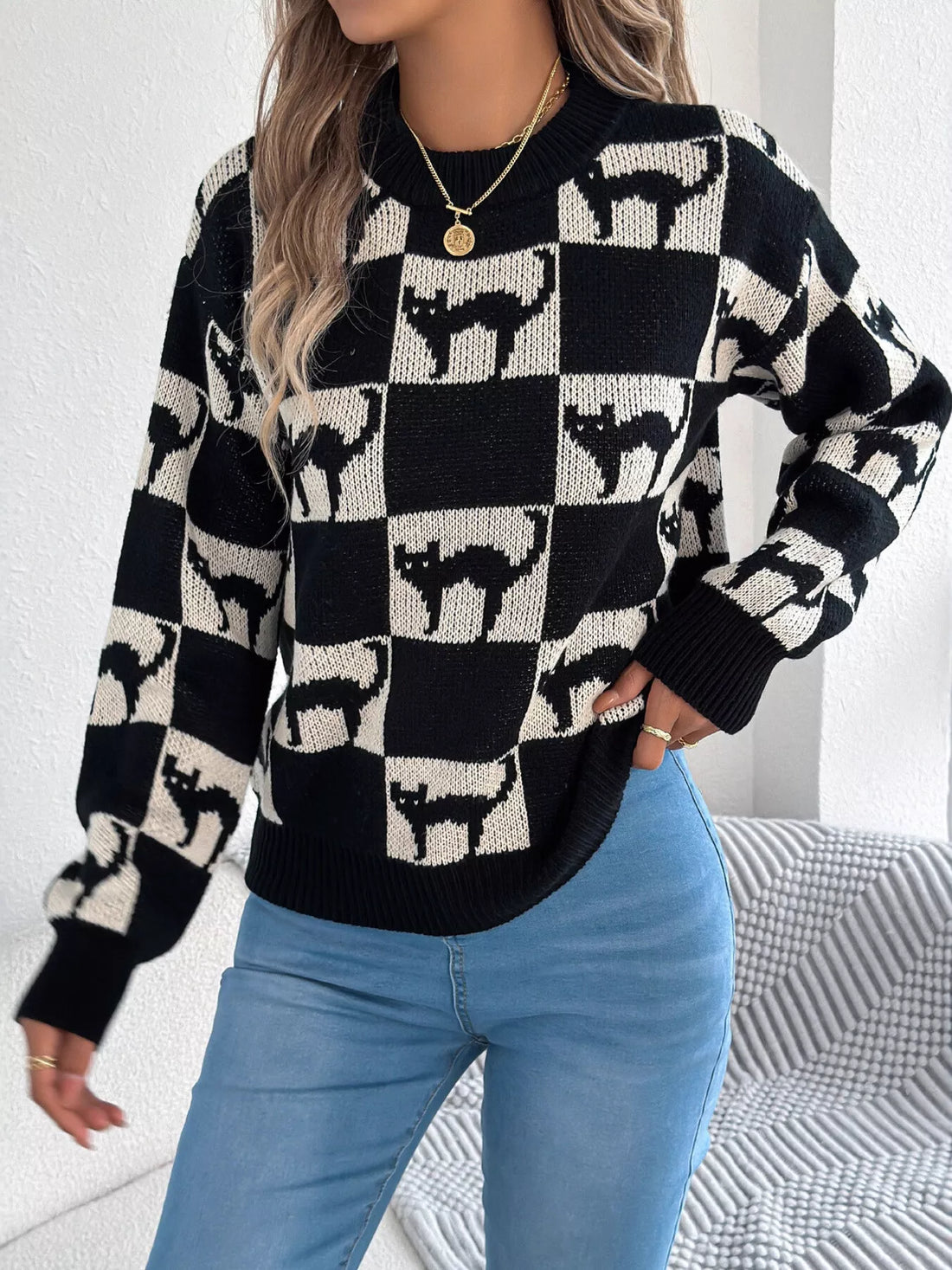 Front view: black and cream ghost checkerboard knit sweater with ribbed collar