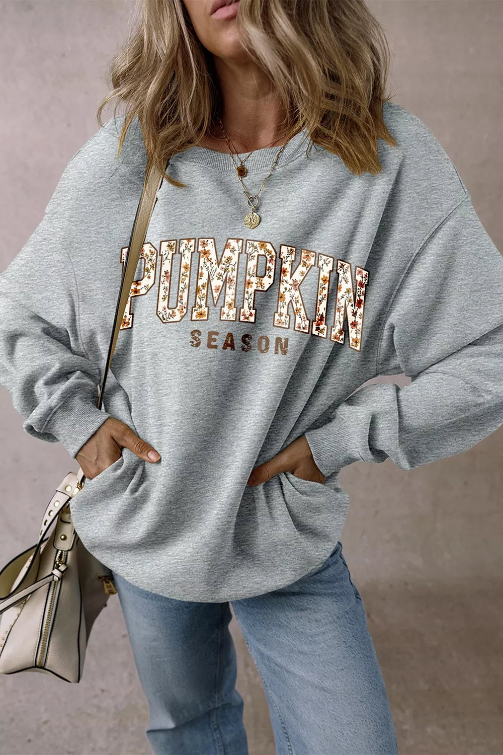 Gray oversized pullover sweatshirt with “PUMPKIN SEASON” graphic print at chest