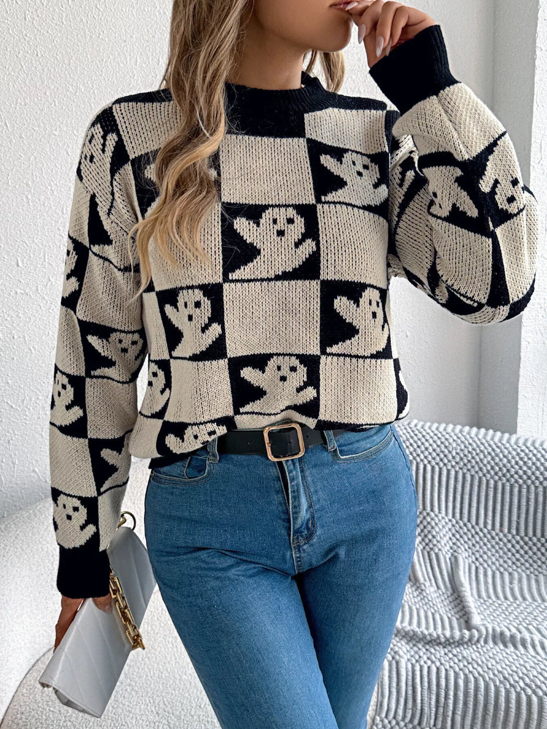 Ghost-pattern checkered round-neck sweater in black and cream, ribbed cuffs and hem.