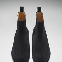 Pair of black suede Chelsea boots viewed from above, showing rounded toes and tan lining