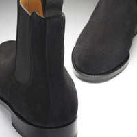 Black suede Chelsea boot showing the elastic side panel, heel, and pull tab