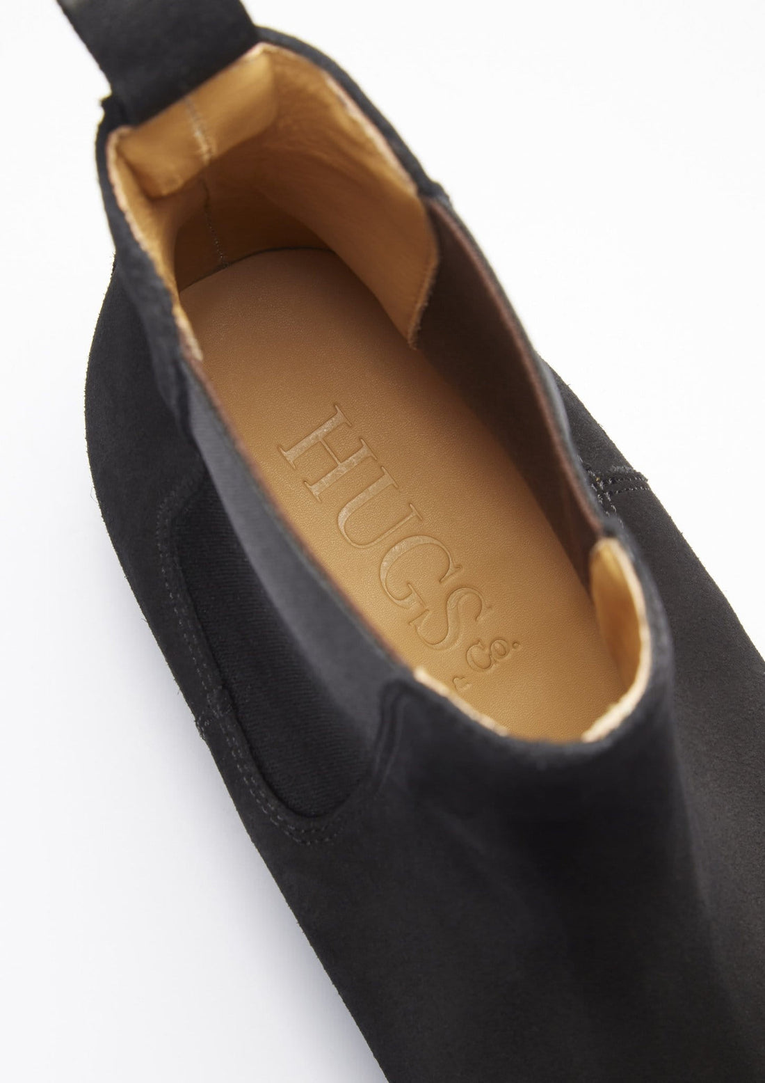 Close-up of black suede Chelsea boot opening with tan Hugs insole