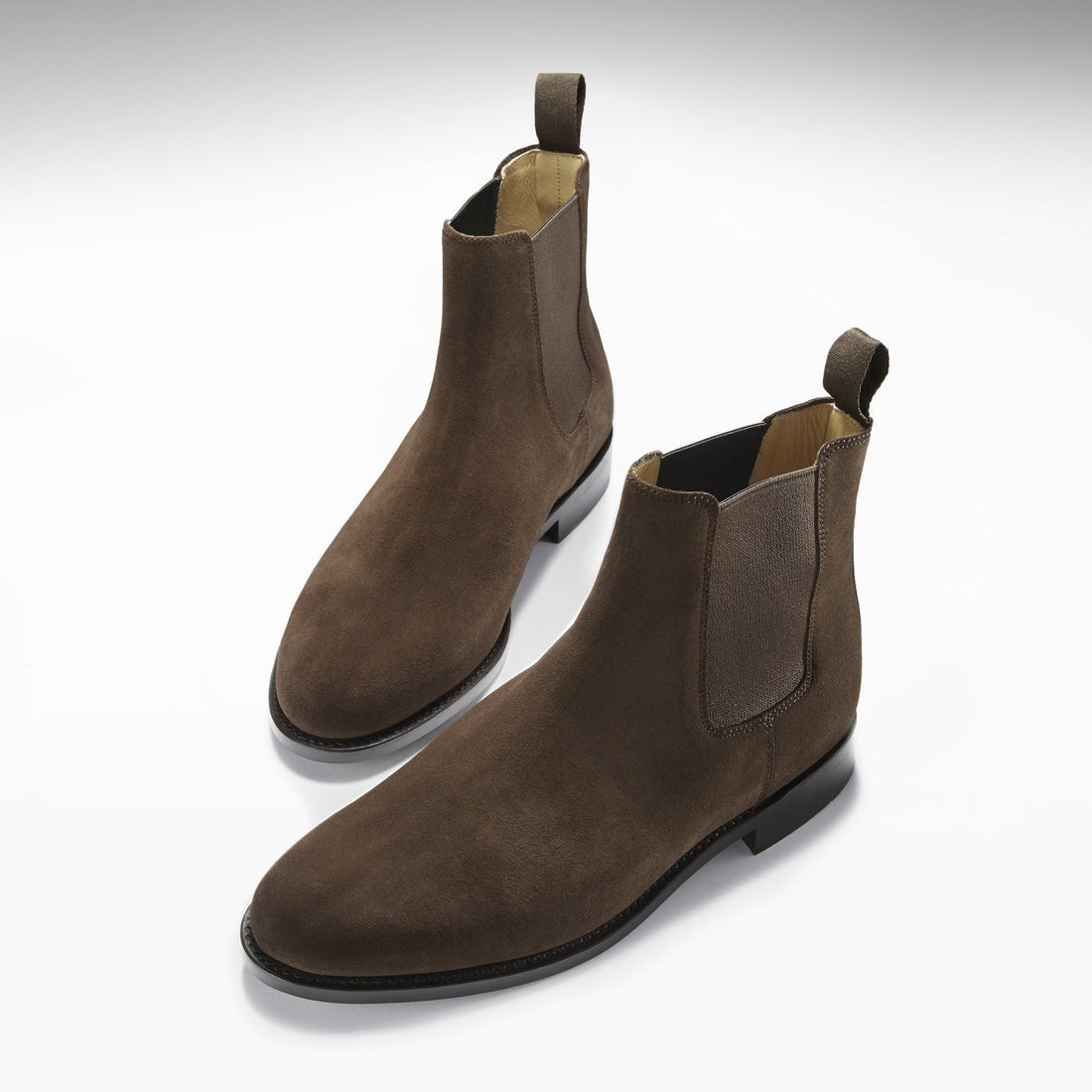 Pair of brown suede Chelsea boots with elastic panels and pull tabs