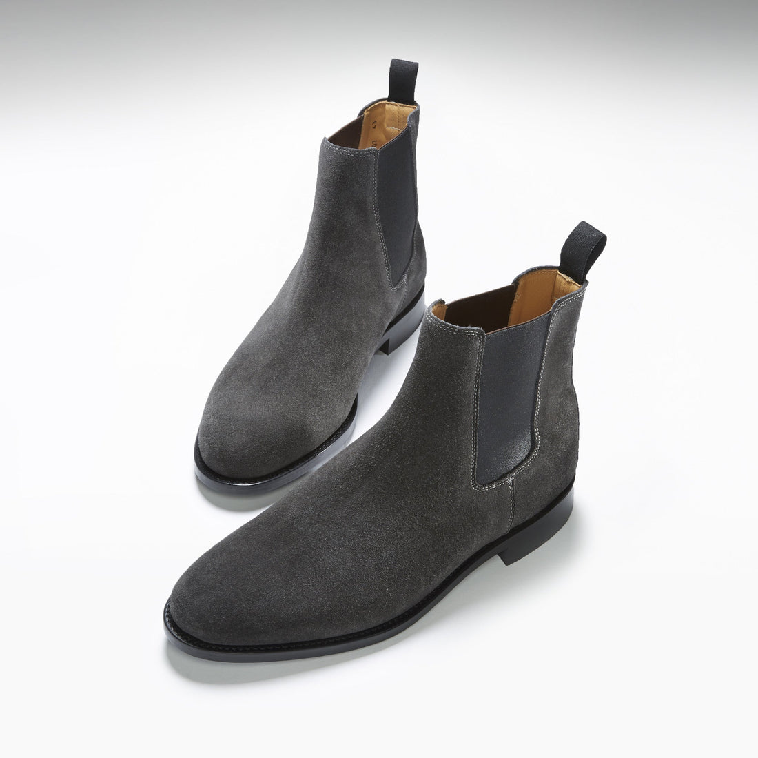 Pair of dark gray suede Chelsea boots with elastic panels and pull tabs