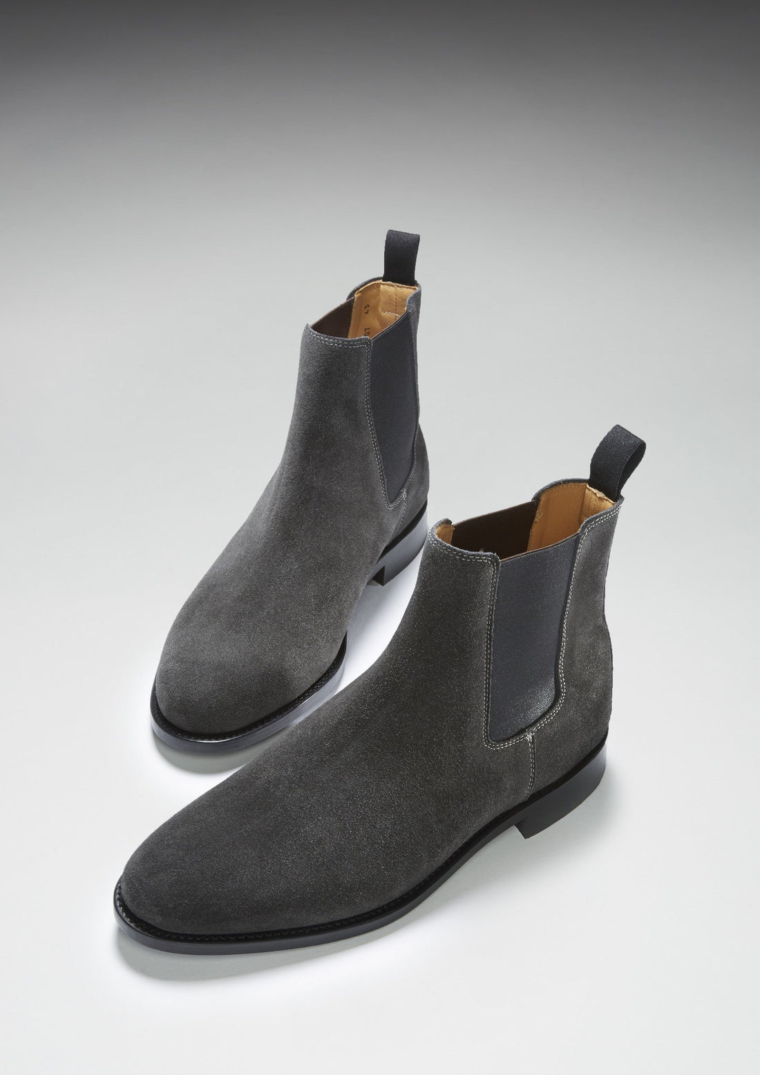 Pair of gray suede Chelsea boots shown from an angled front view
