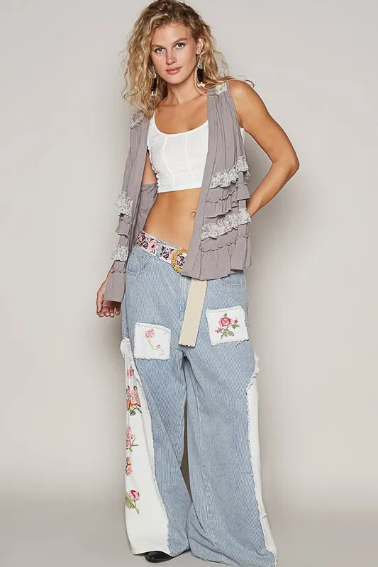 Grey sleeveless open-front cardigan with ruffled tiers and floral trim