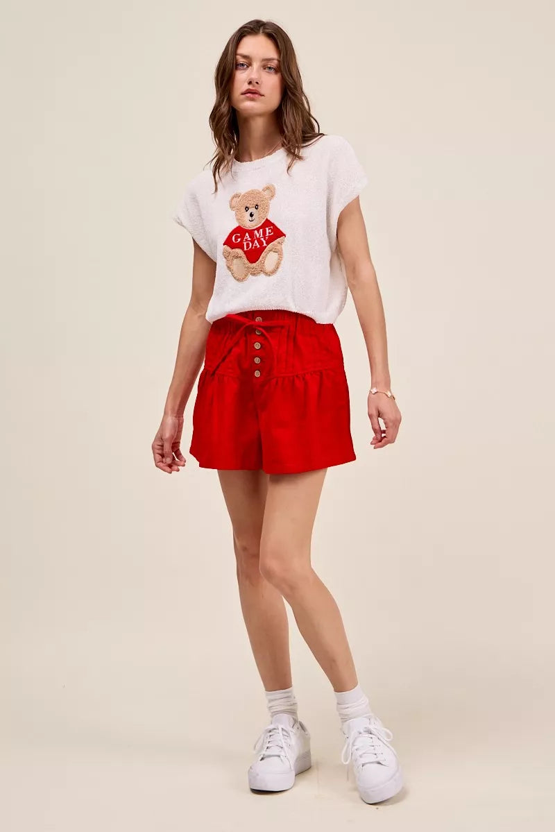 Red denim shorts with elastic waistband, front buttons, and waist tie.