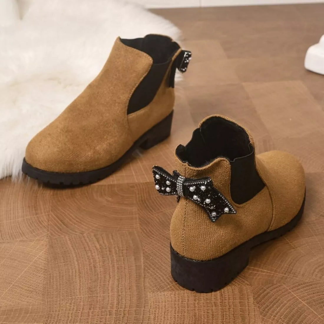 Tan suede ankle boots with round toe, block heel, and jeweled bow at collar