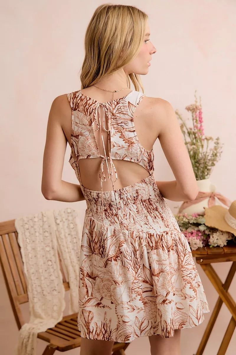 Back view: taupe shell print smocked mini dress with open-back cutout
