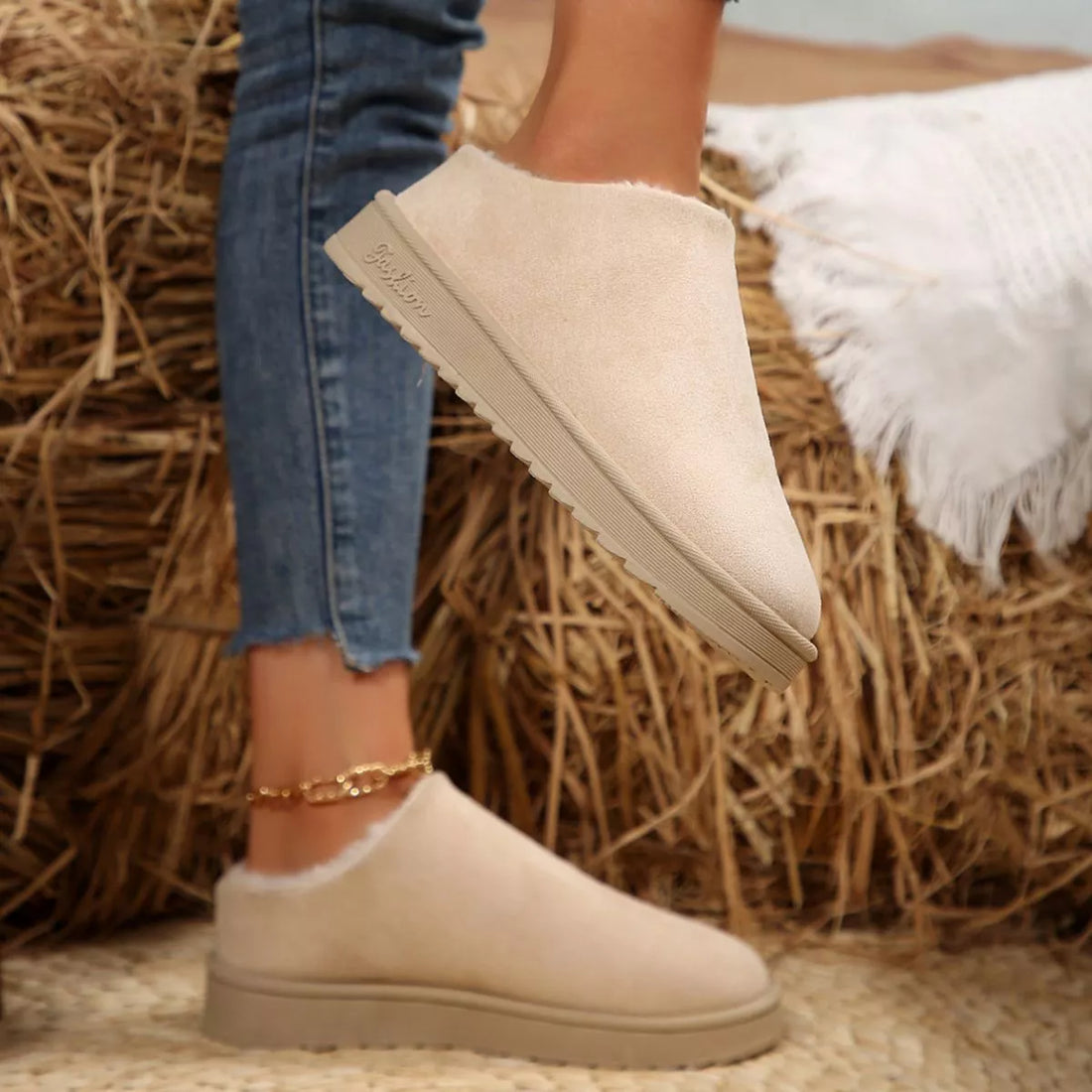 Off-white ankle boots with plush lining, round toe, side view of low wedge sole.