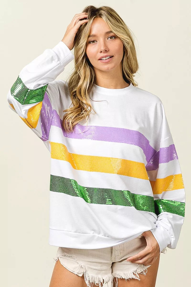 White pullover sweatshirt with sequin purple, yellow, and green stripes and round neckline