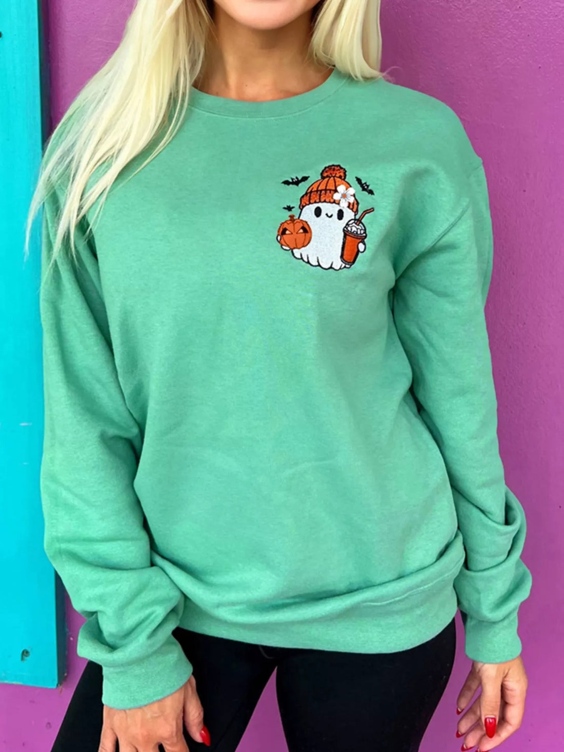 Turquoise crewneck sweatshirt with embroidered ghost and pumpkin patch on front