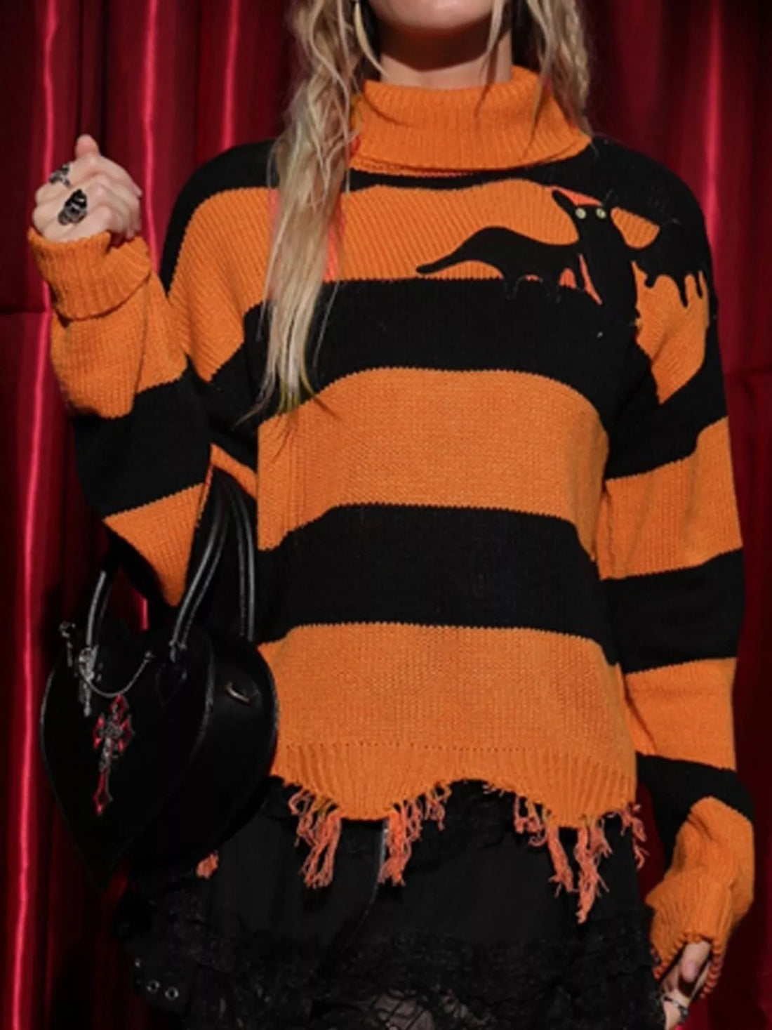 Orange and black striped turtleneck sweater with bat graphic, raw hem fringe
