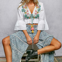 Ivory cropped blouse with floral embroidery, tassel tie and bell sleeves