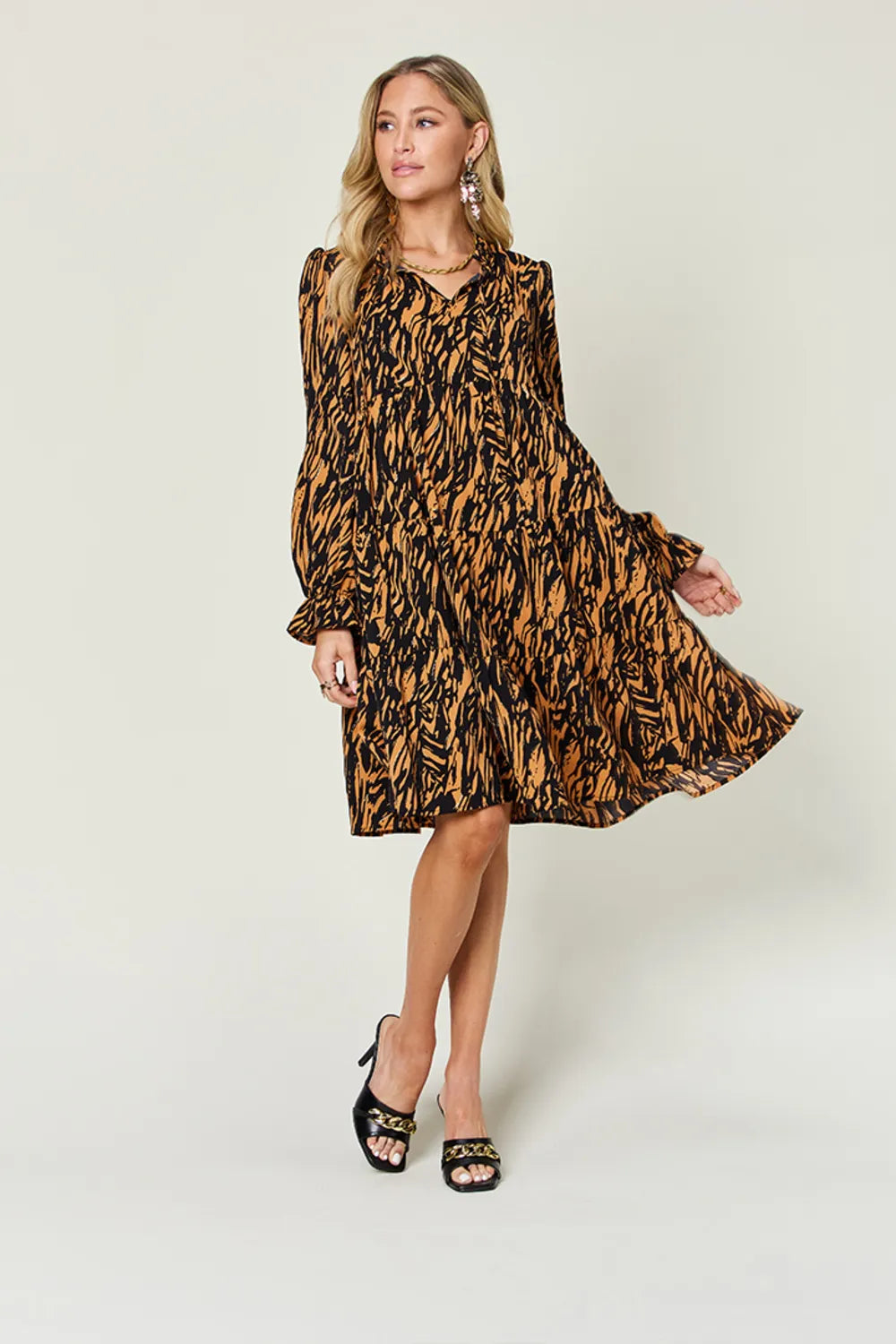 Caramel and black printed swing dress with long sleeves and ruffled skirt
