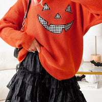 Orange knit sweater with jack-o-lantern graphic, long sleeves, round neck