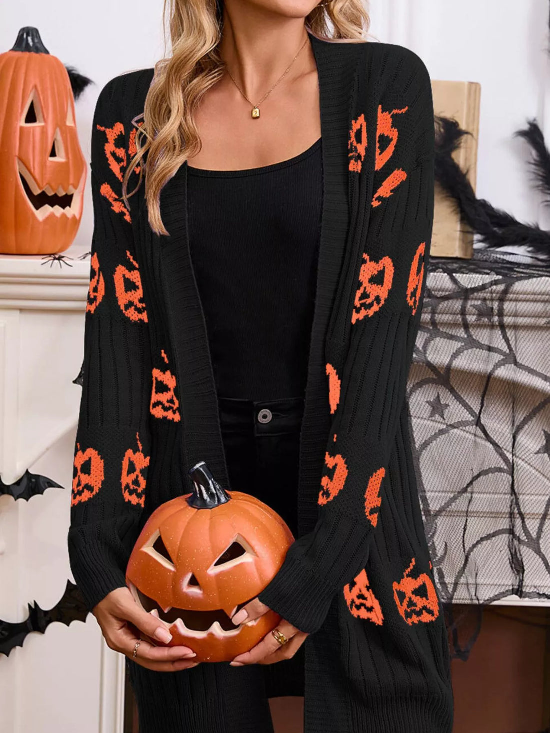 Black open-front knit cardigan with repeating orange pumpkin jack-o&
