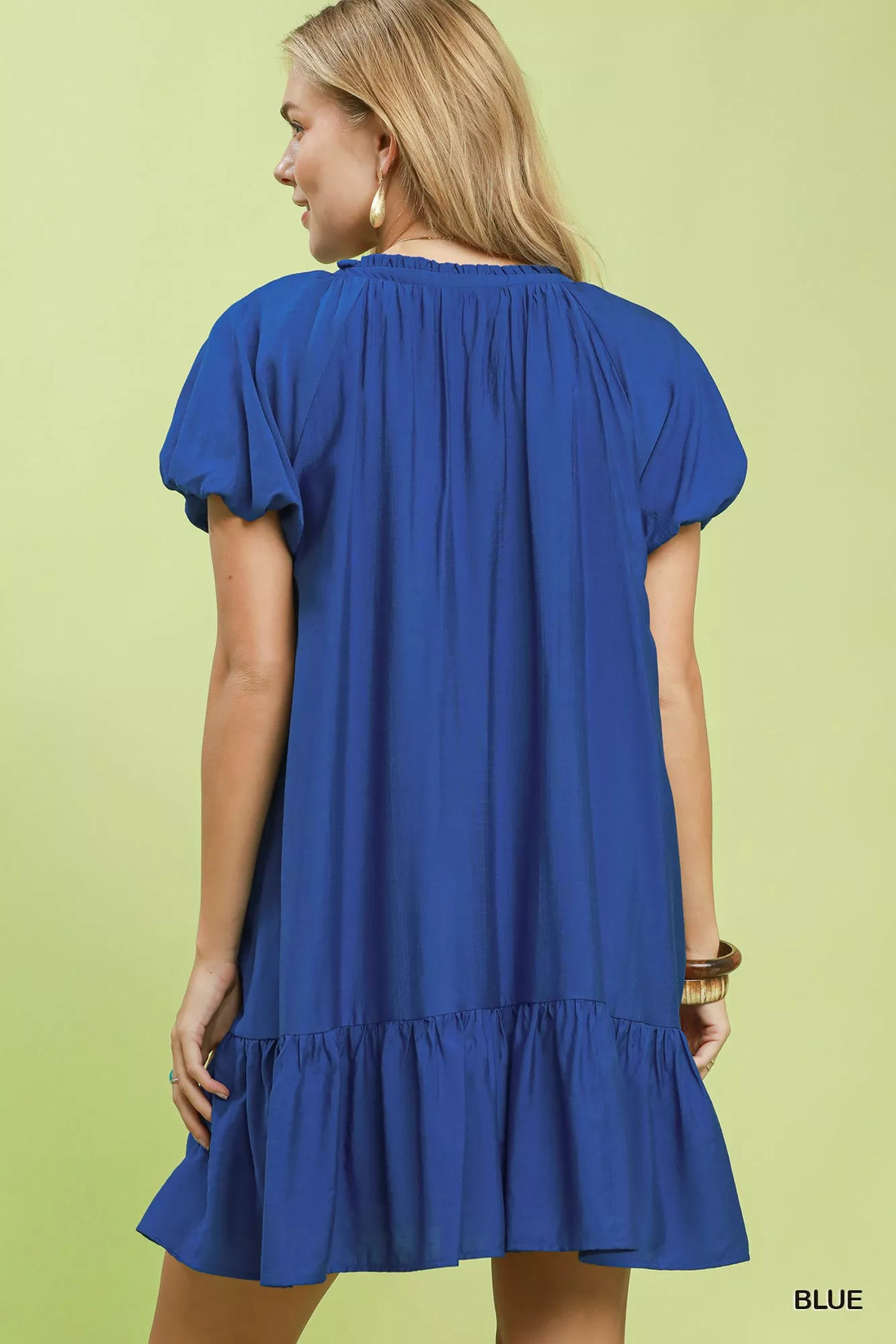 Back view of blue shift mini dress with short puff sleeves and ruffled hem.