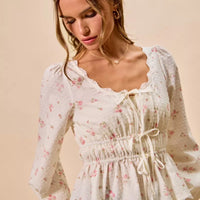 White floral clip-dot blouse with ruched elastic waist, lace-trim neckline, and long puff sleeves