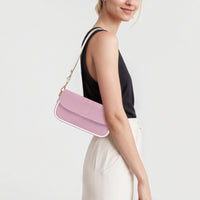 Pastel pink mini crossbody bag worn over shoulder with front flap and chain strap