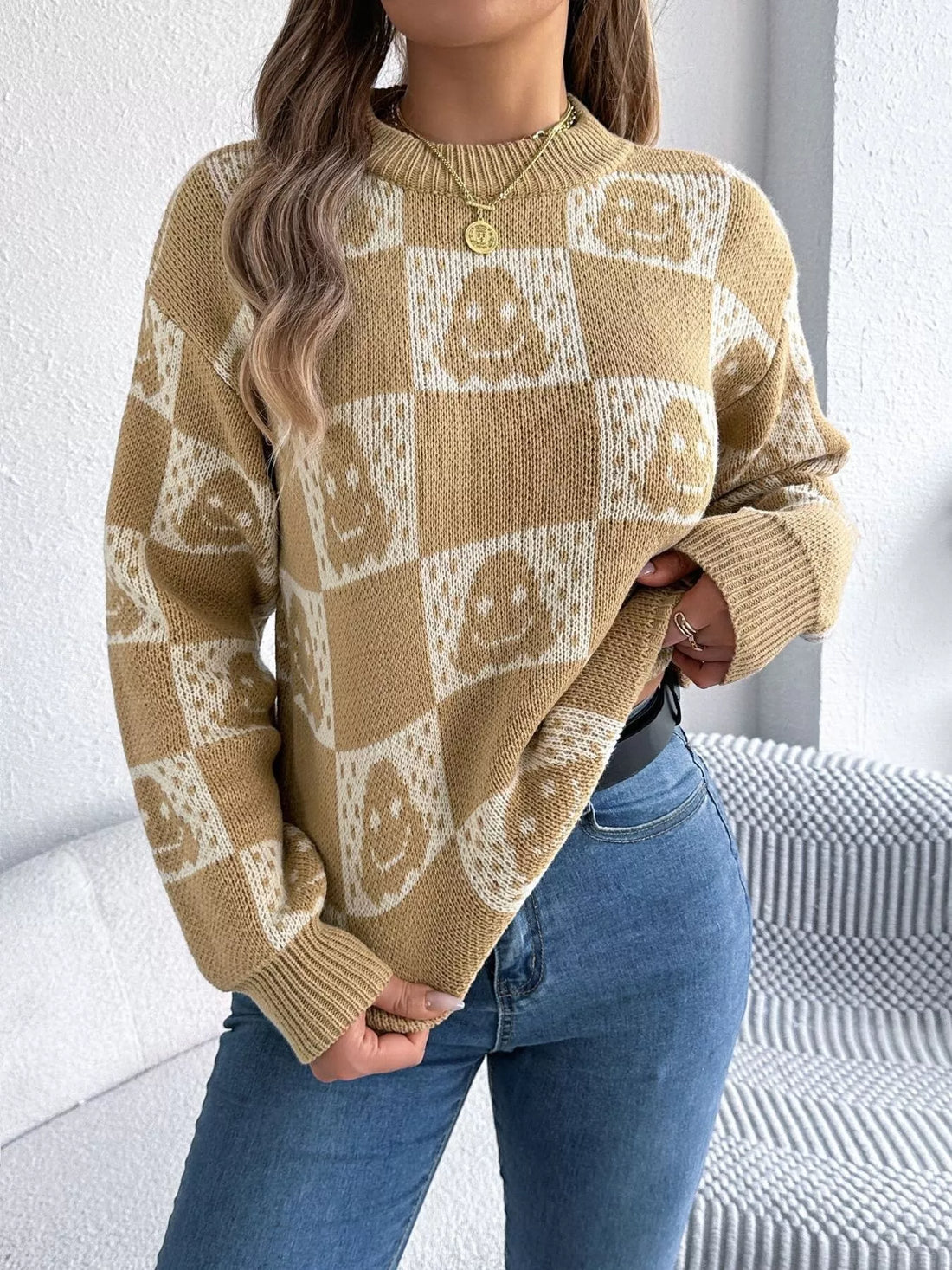 Tan checkerboard Halloween sweater with jack-o-lantern face graphics and ribbed cuffs