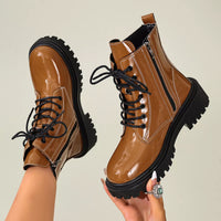 Tan lace-up block heel boots with black side panels, glossy finish, and chunky tread