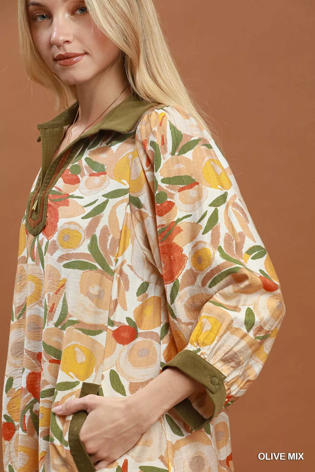 Floral shift mini dress close-up with olive contrast trim and three-quarter puff sleeve