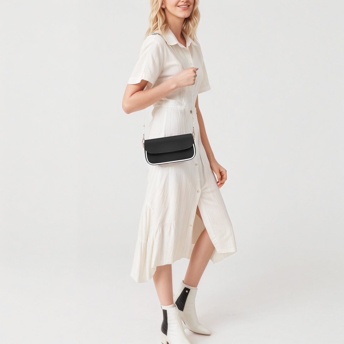 Black mini shoulder bag worn crossbody with gold chain strap and top flap