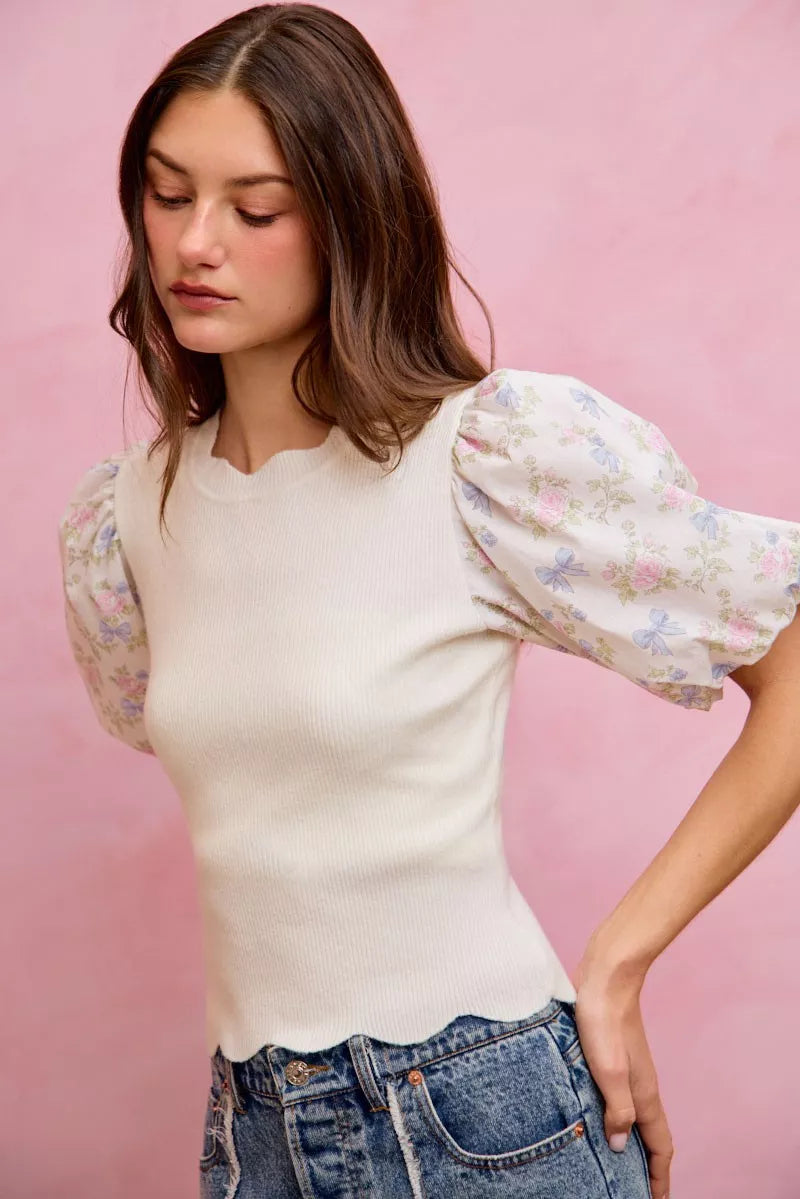 White rib knit sweater top with floral contrast puff sleeves and scalloped hem