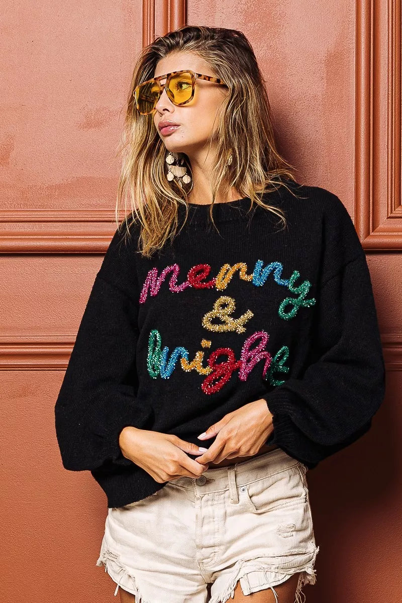 Black sweater with multicolor tinsel "Merry & bright" lettering, crewneck front detail.