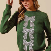 Hunter-green Christmas sweater with silver sequin bow ribbon graphic on front