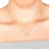 Gold evil eye necklace with small round blue eye charm on fine chain