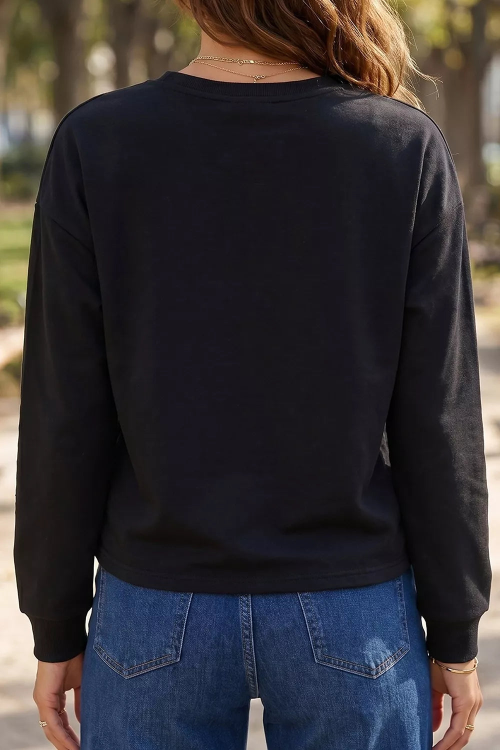 Black long sleeve sweatshirt back view, plain round neckline and cuffs