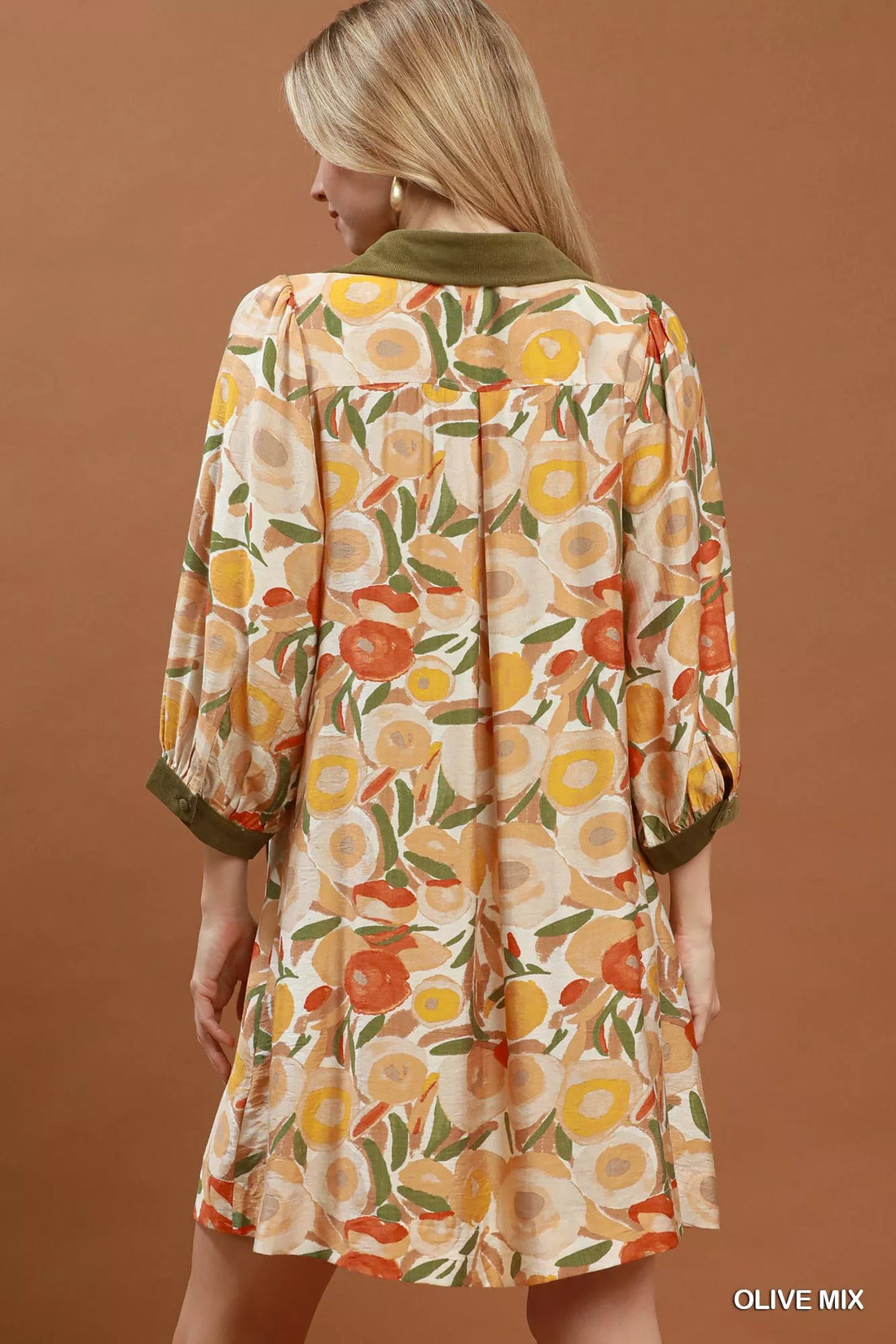 Floral shift mini dress back view with olive contrast trim and three-quarter puff sleeves