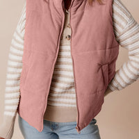 Dusty pink corduroy stand-neck zipped puffer vest with pockets and full zipper.