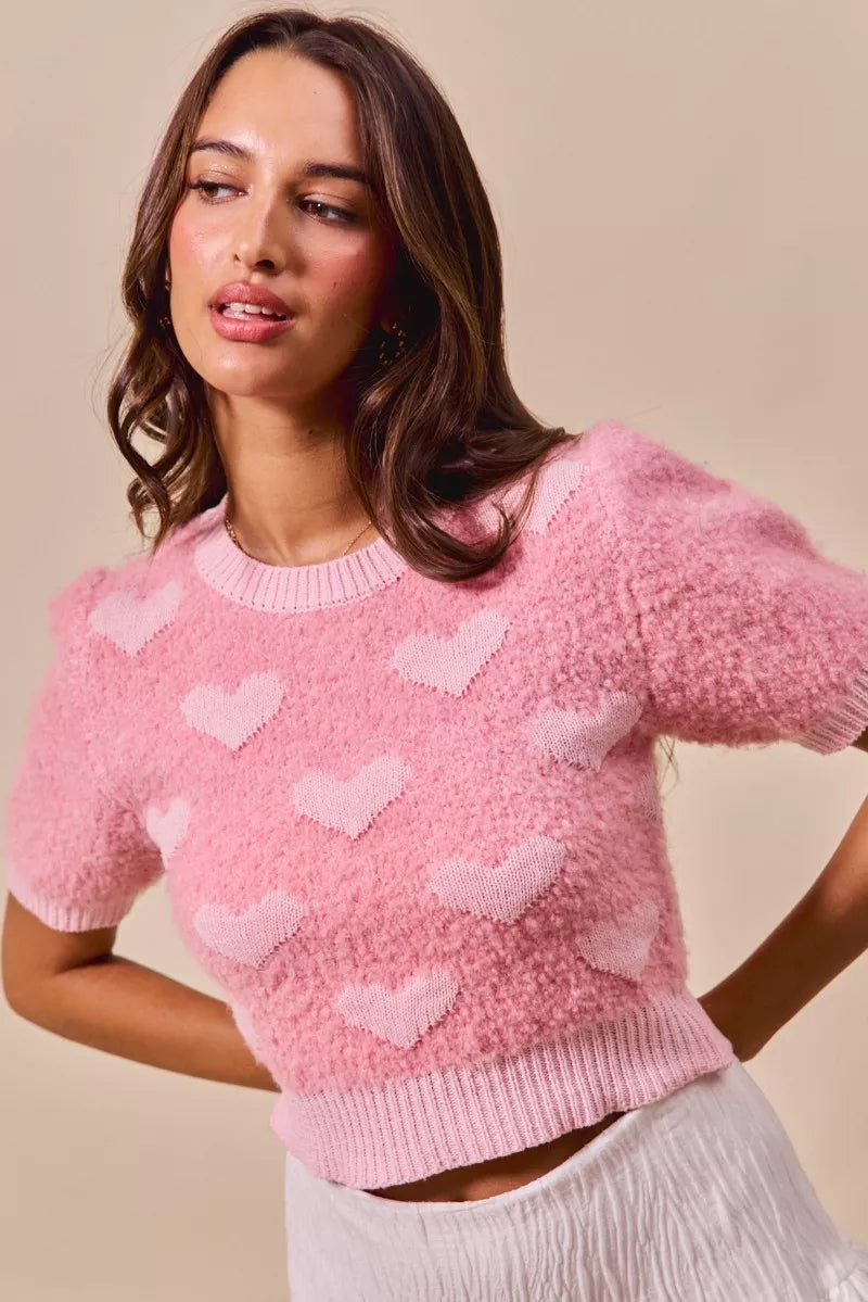 Pink cropped heart-print sweater with crew neckline and short sleeves, ribbed hem