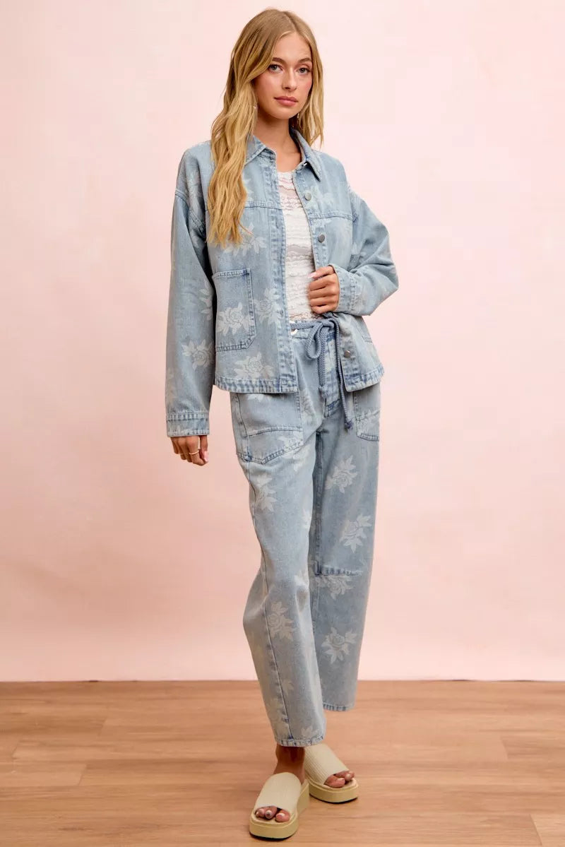 Washed light blue denim jacket with white floral print, worn with matching pants