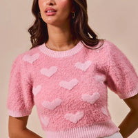 Pink cropped heart-pattern sweater with crew neck and short sleeves, ribbed cuffs