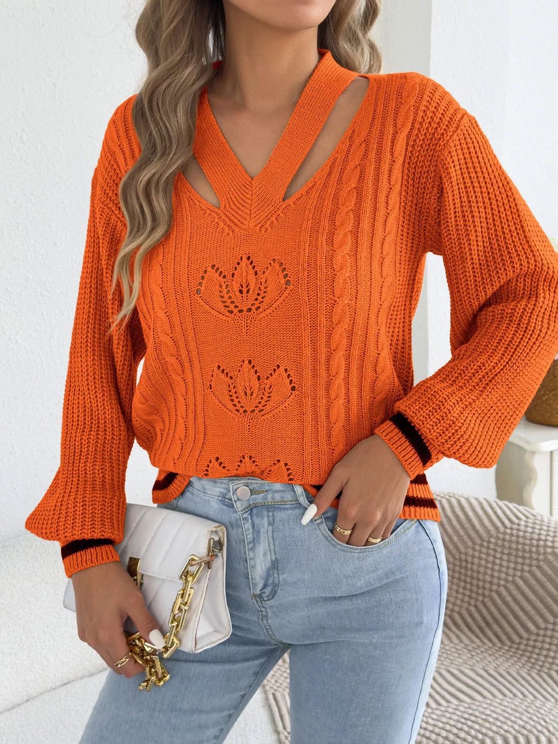Orange cutout cable knit sweater with V-neck, cable texture, and knit lotus motifs