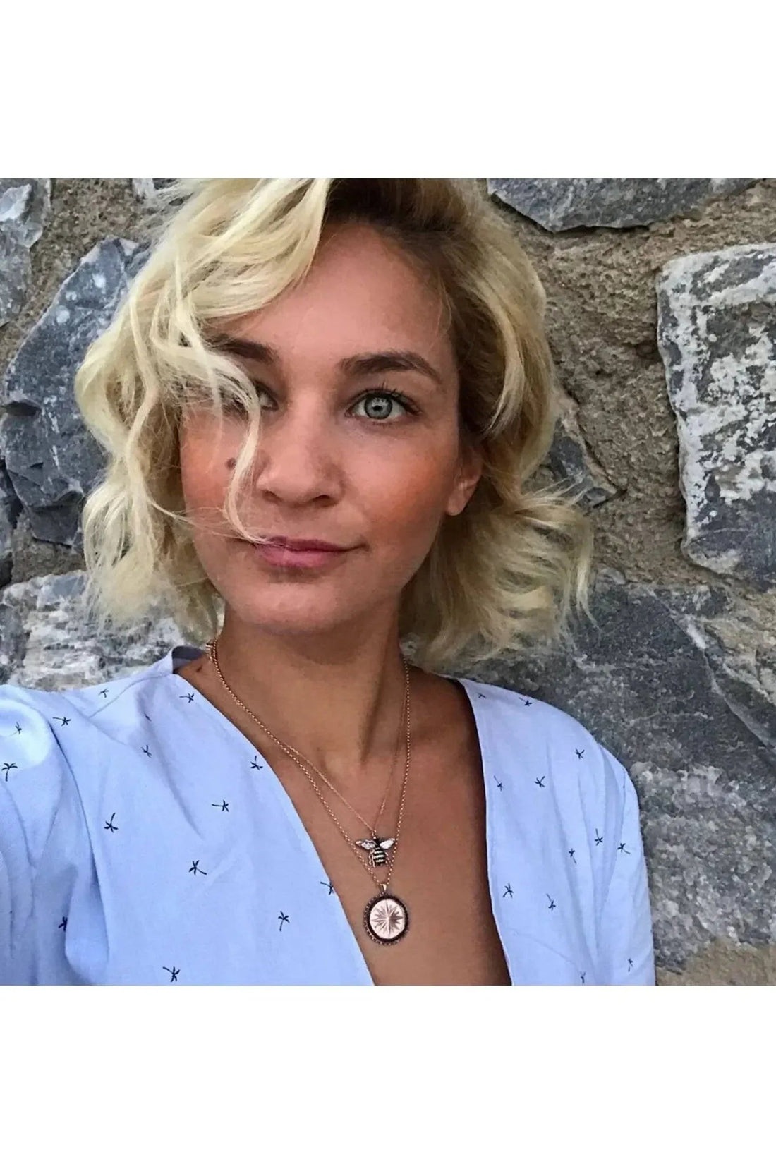Rose gold honey bee pendant necklace worn at the neckline with a short chain