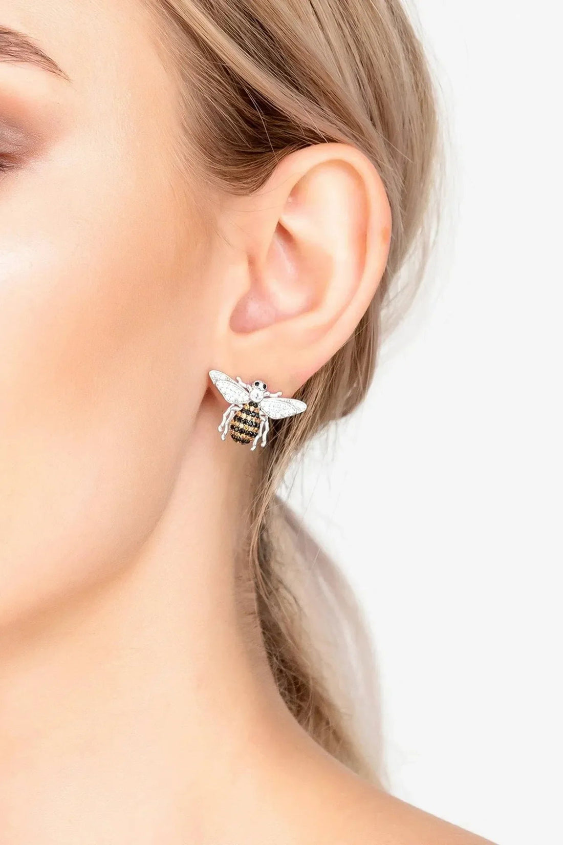 Silver honey bee stud earrings on ear, small crystal bee with wing sparkle