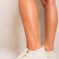 Beige slip-on trainers with side zipper detail and low platform sole