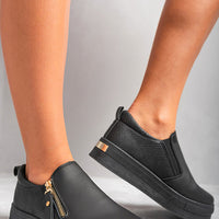 Black slip-on trainers with side zipper detail and gold-tone hardware on chunky sole